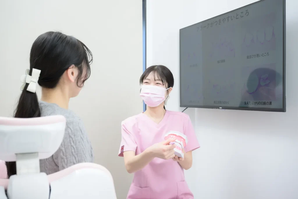 歯科衛生士が保護者にお口の状態を説明している様子